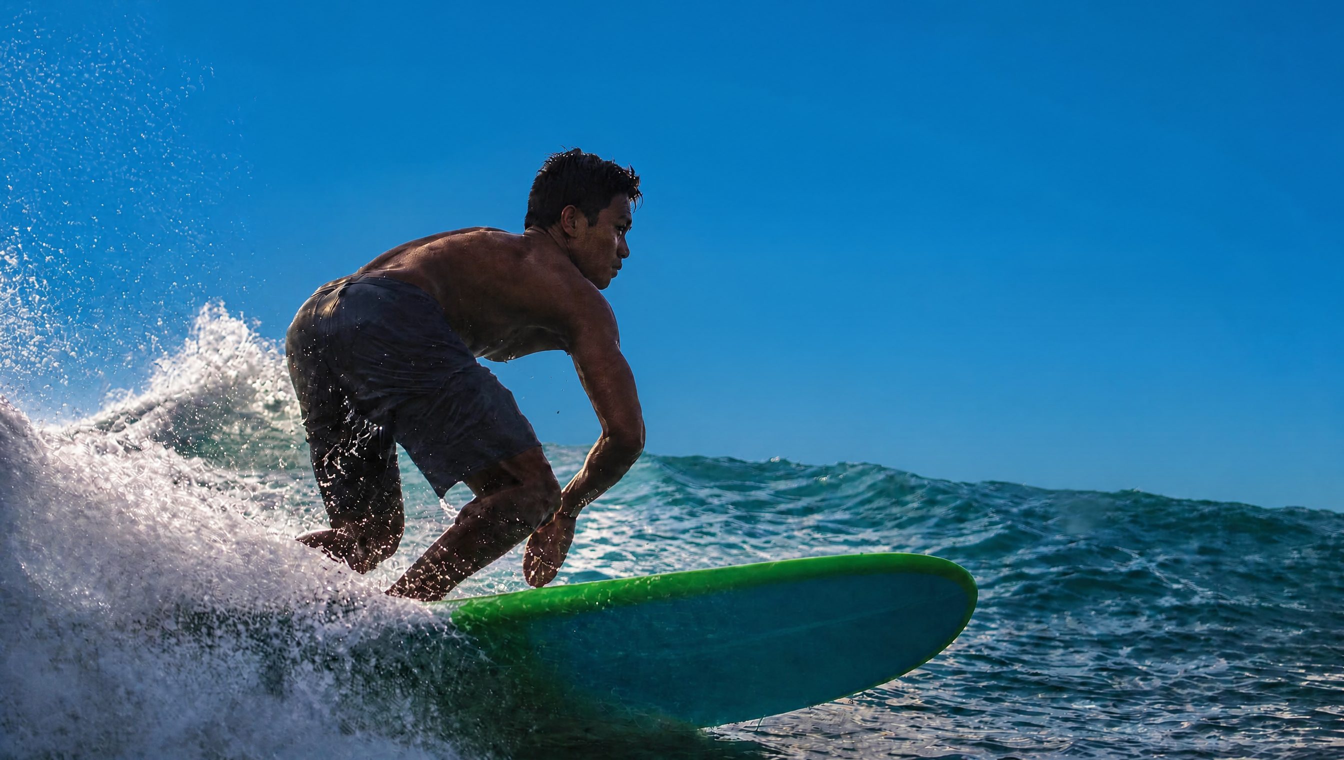 A surfer turning off the lip on a clean blue day